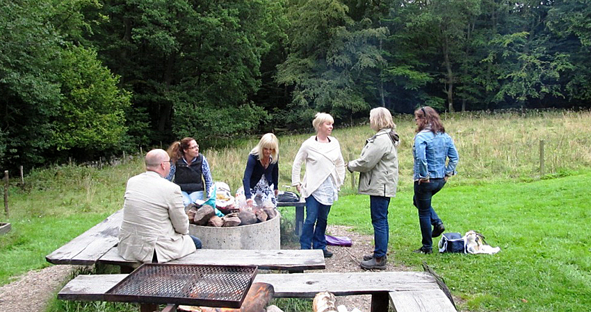 a group of people around a fire - bbq