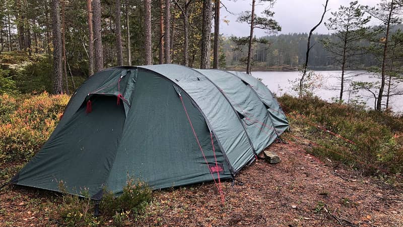 Länsstyrelsen Västra Götaland Tält uppställt i tallskog vid en sjö.