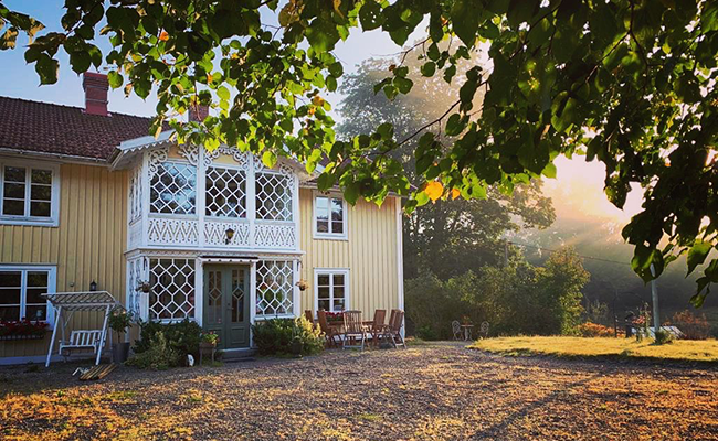 Toftahult gård, en gul villa med vita knutar och snickarglädje.