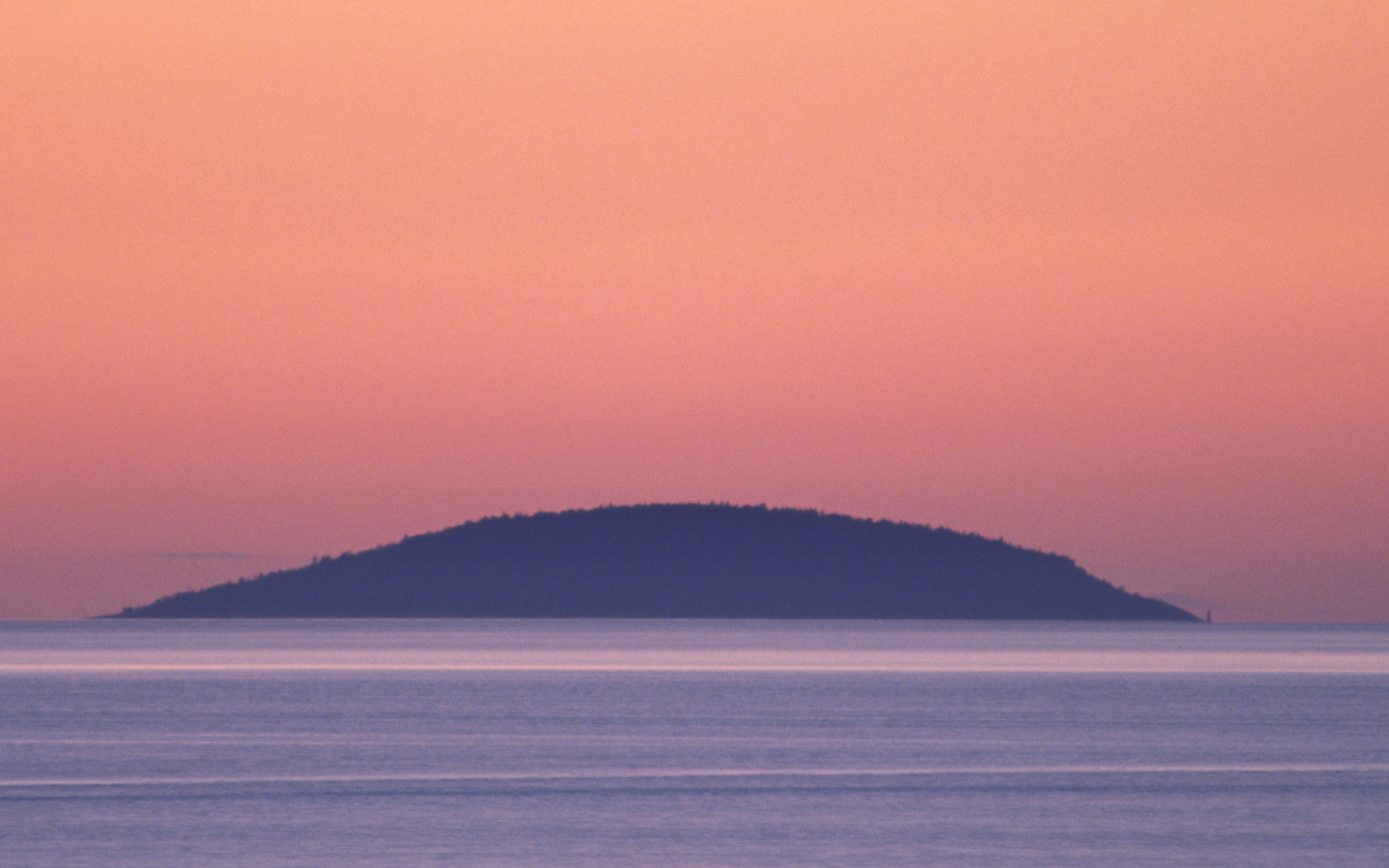 Rosa himmel med siluett av ön Blå Jungfrun i sikte