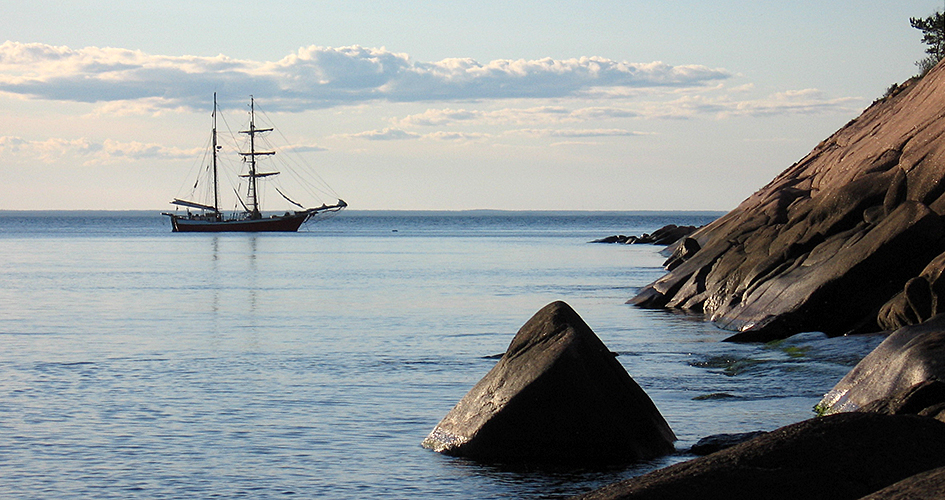 Two-masted ship on calm waters outside Blå Jungfrun National Park.