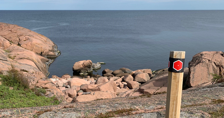 Trail markings on cliffs bordered by the sea.