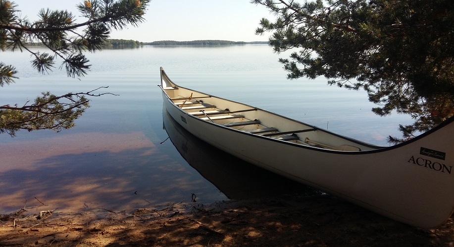 En kanot ligger ankrad vid ett vattenbryn.