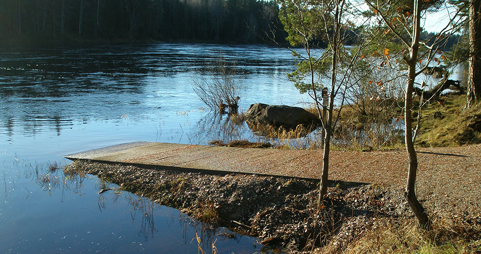 An accessibility-adapted ramp that leads down to the water.