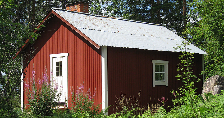 En röd stuga i naturen.