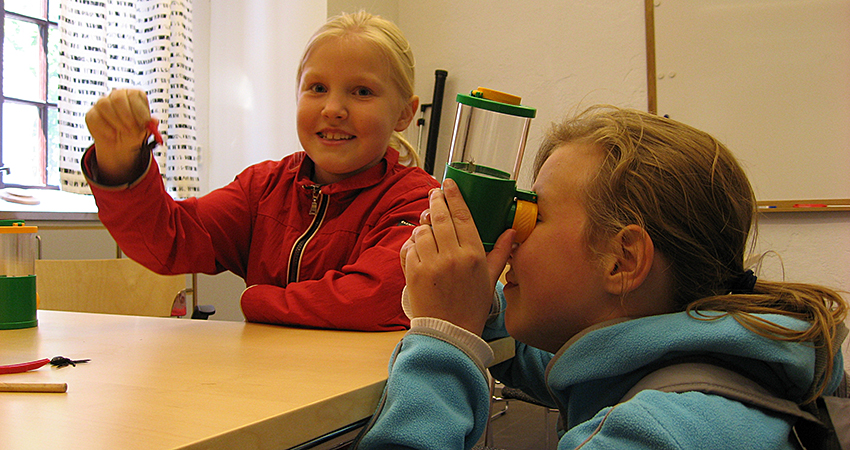 Two children looking under a microscope.