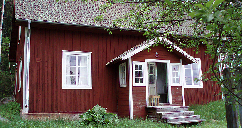 Faluröd stuga med farstukvist.