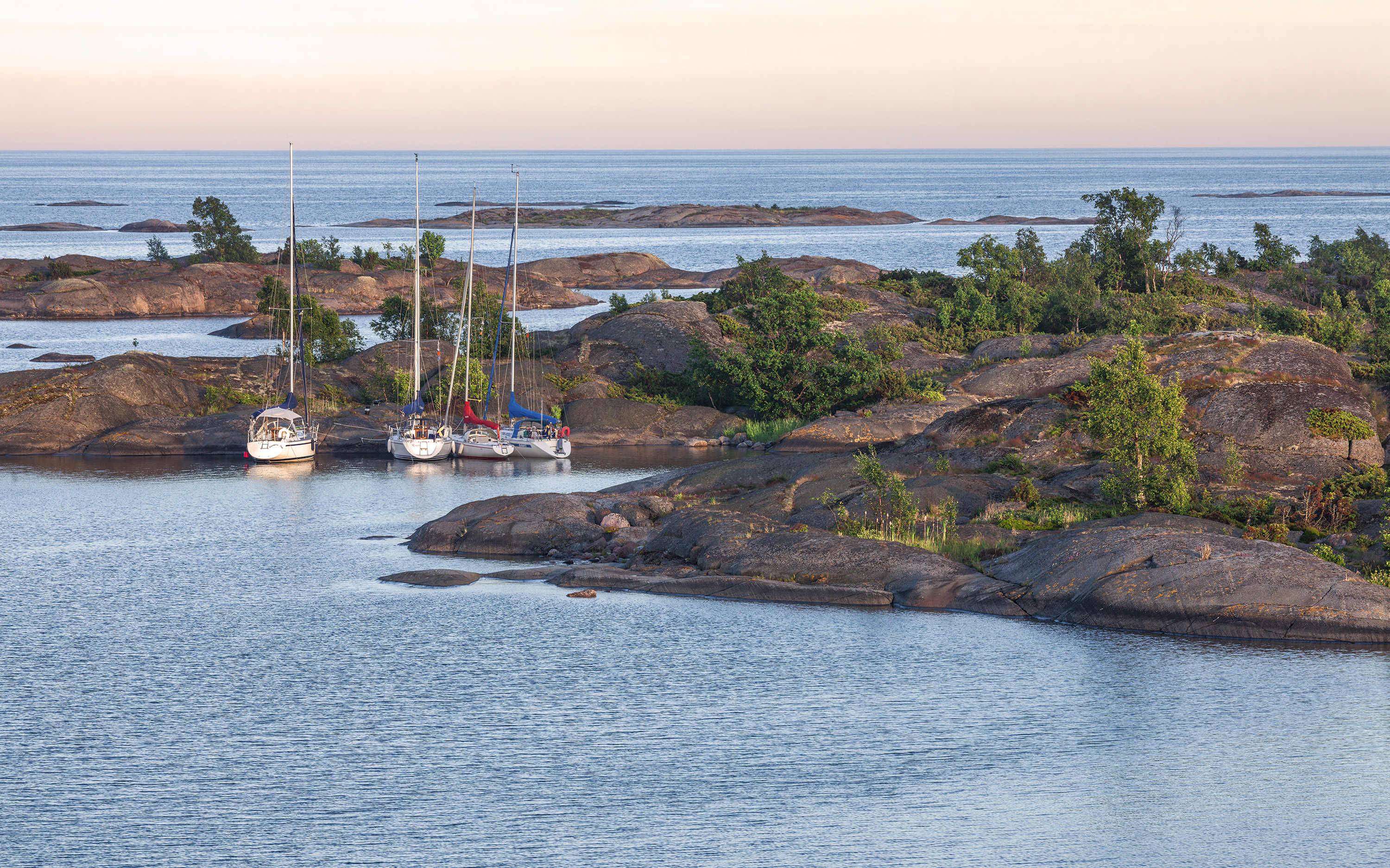 Sailboats are anchored at the cliffs.