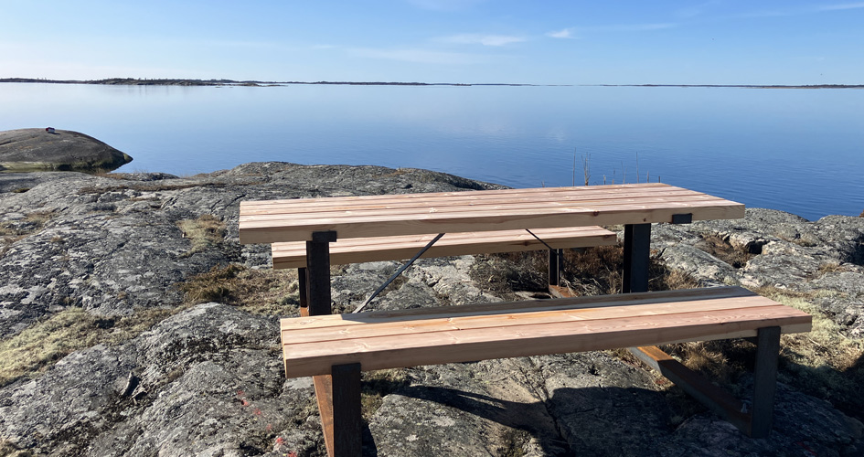 Utsikt från Dromudden på Bullerö Bänk på ett berg med utsikt över vattnet och öarna.