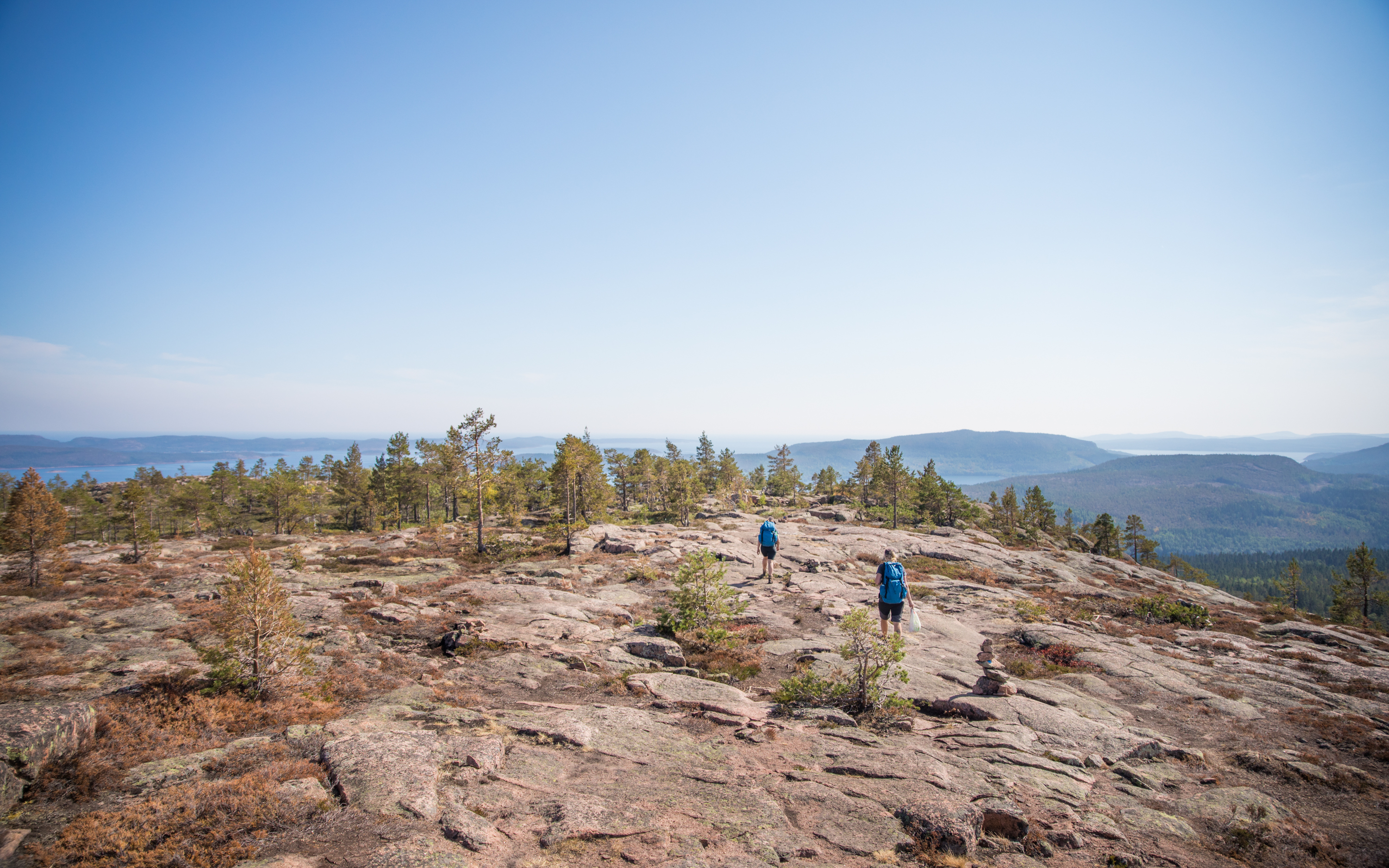 Two people hiking over cliffs with nice view.