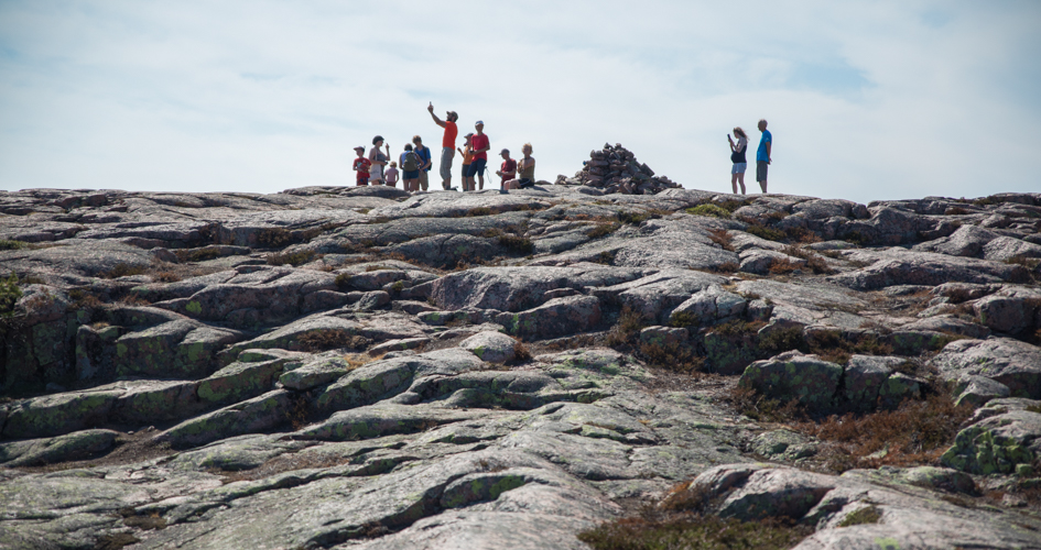A group of people standing an a mountain top.