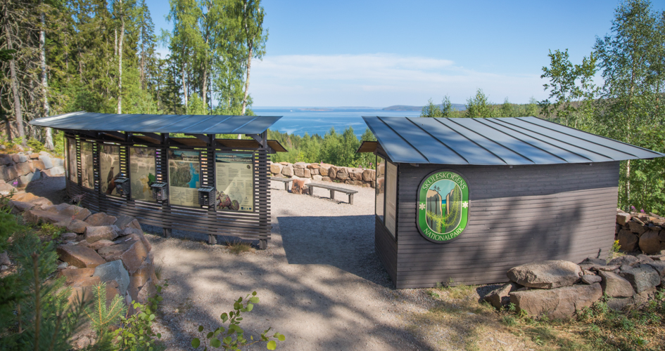 Wooden buildings with information signs and benches.