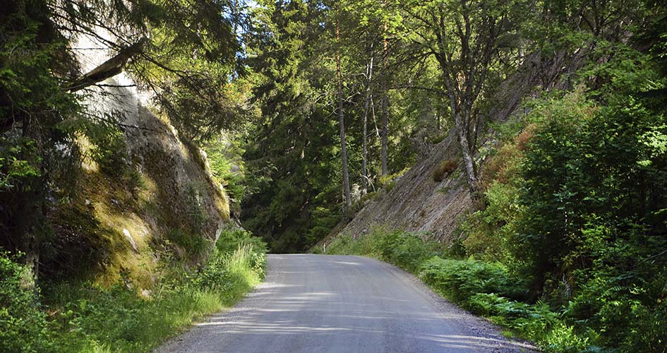 Väg passerar genom smal passage mellan sluttande bergssidor