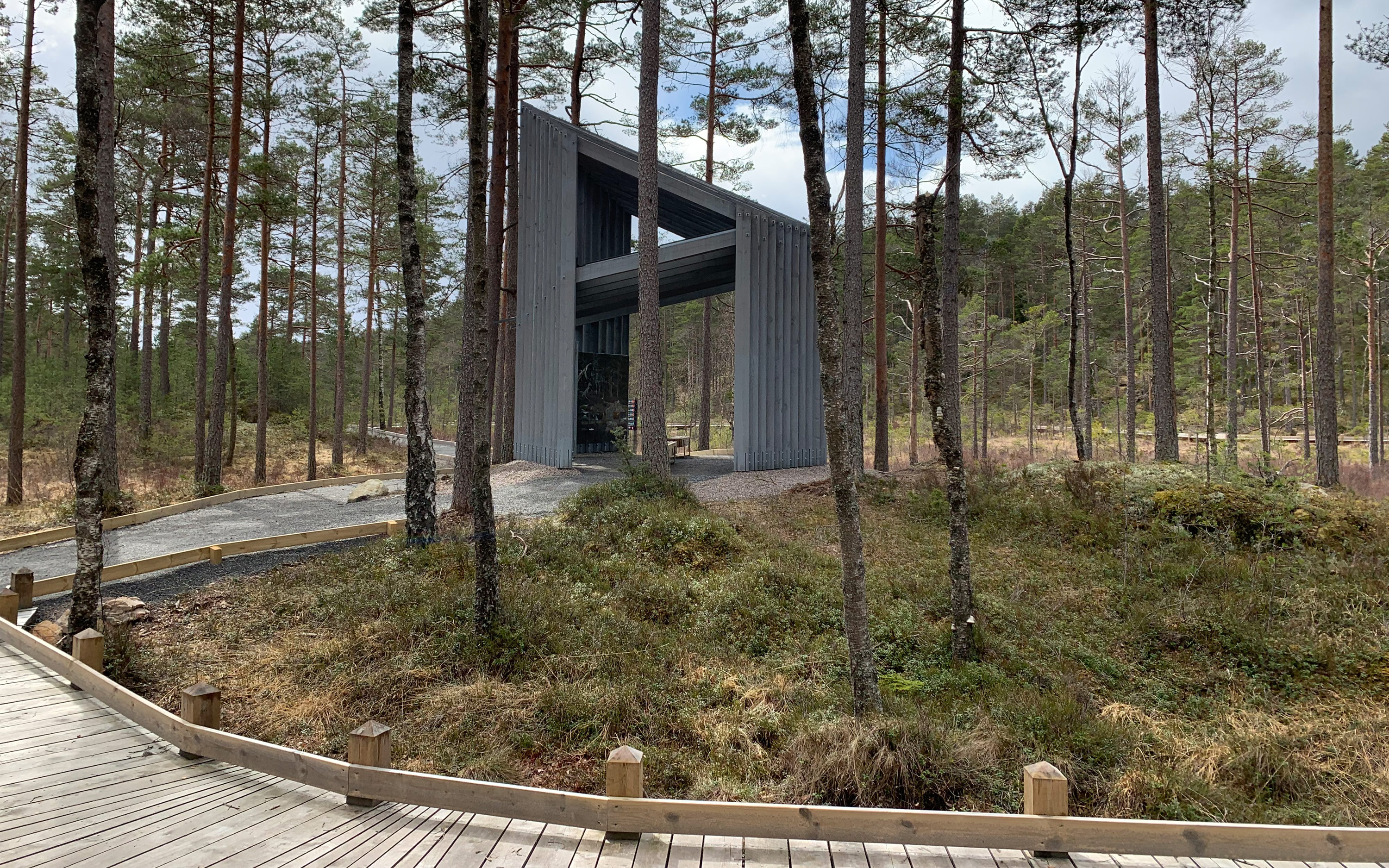 Träbyggnad i skogen med träspång i förgrunden