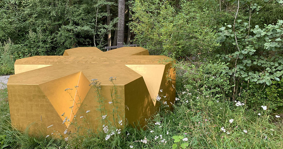 En stor guldstjärna ligger vid en skog. 