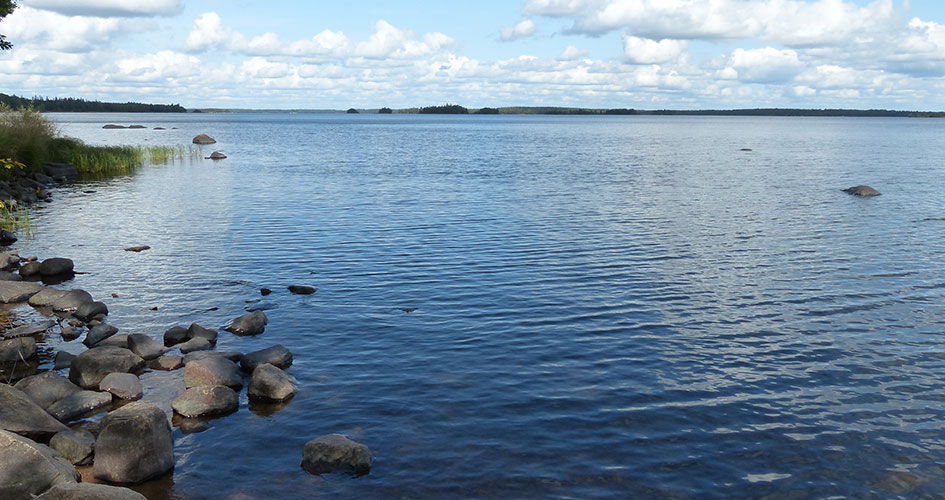 View of a lake with sky and islands in the background.