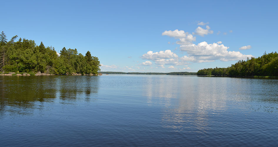 View of a lake with sky and islands in the background.