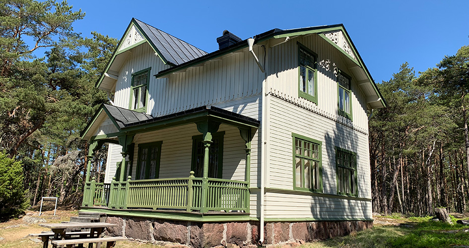 Jaktvillan i Djurö nationalpark. Vit villa med grönmålade detaljer som terass och fönsterkarmar