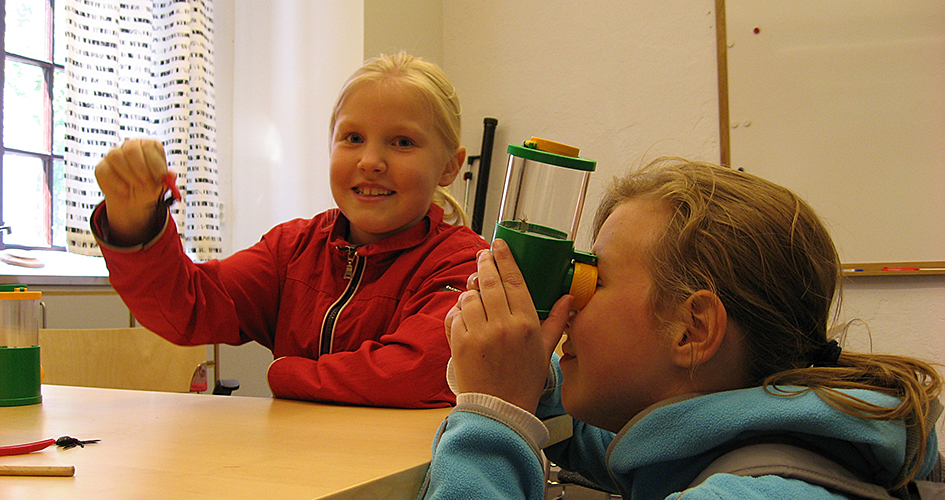 Two children looking under a microscope.