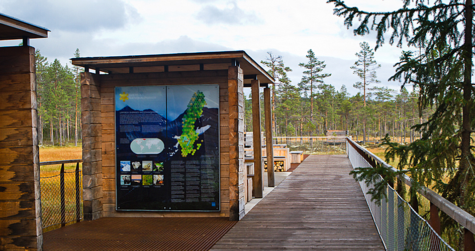 Wooden footbridge and signs with information about the national park.