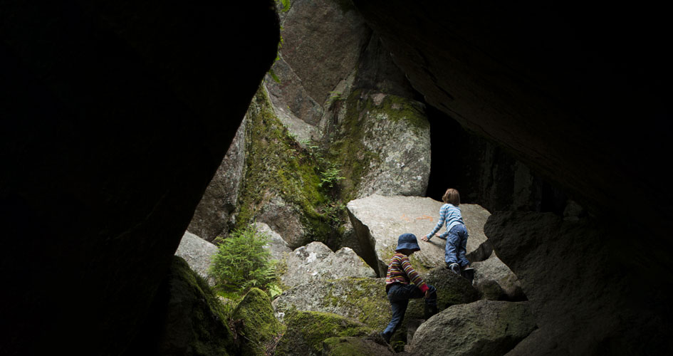 Två barn klättrar i en grotta.