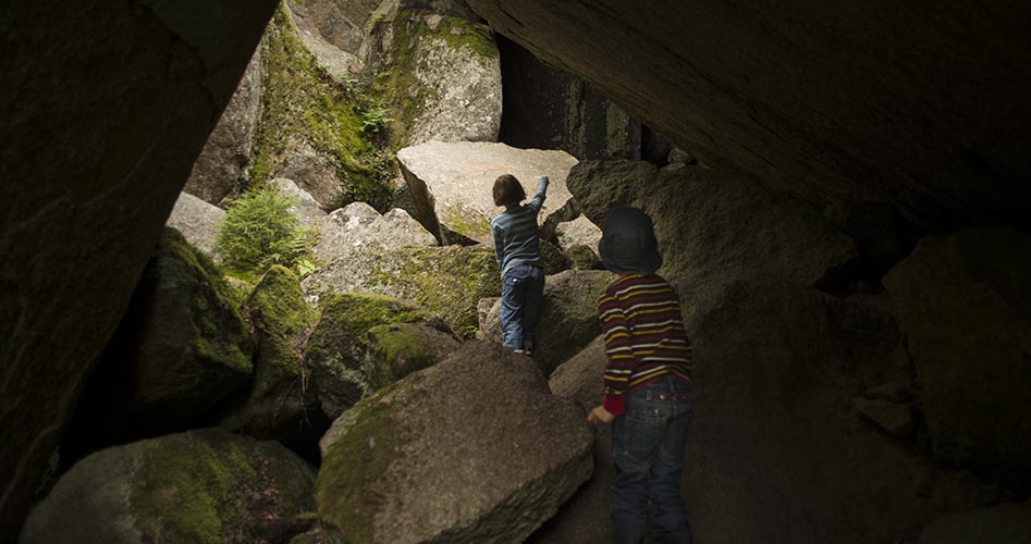 Barn leker i en grotta.