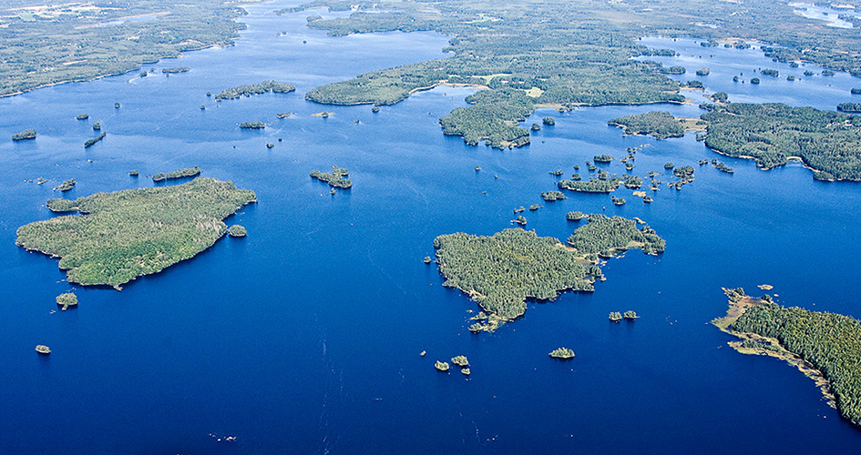 Flygbild över Åsnen - många öar i klarblått vatten.